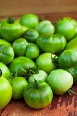 Immature Green Tomatoes On Wooden Brown Board Top View And Close Up.