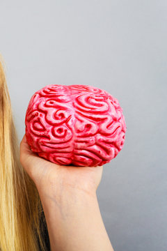 Weird woman holding brain having idea