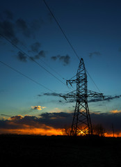 Power lines against the sky at sunset
