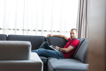Obraz premium Man using laptop in living room