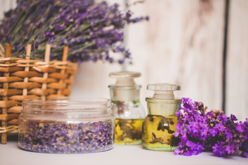 Obraz na płótnie Canvas Lavender oil with fresh flowers on wooden background.