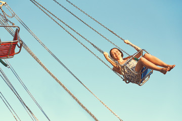 Young girl on a whirligig in amusement park. - 162429306