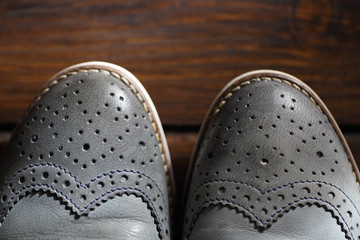 Grey oxford shoes on wooden background