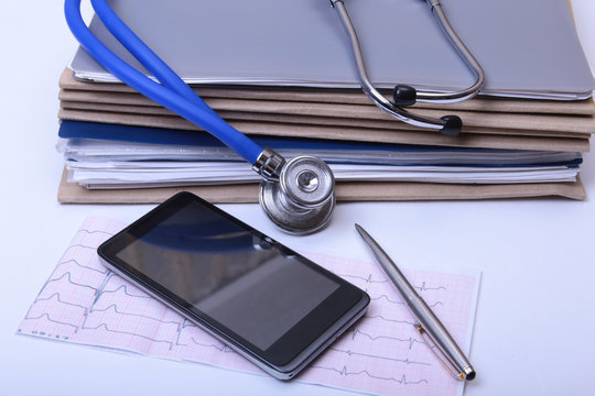 Closeup Folder file, stethoscope on a rx prescription, red heart and phone isolated on white background.