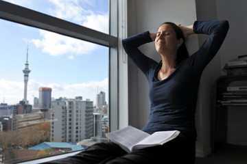 Happy young woman reading a book in morning light. 