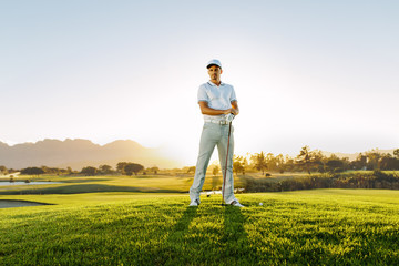 Male golfer standing on golf course - obrazy, fototapety, plakaty