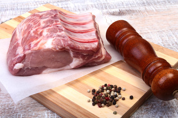 Raw pork chops and spice grinder on cutting board. Ready for cooking.
