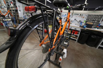 Orange bike in the mechanical workshop for repair