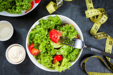 healthy salad with garlic cream sauce or yogurt and fork, diet concept