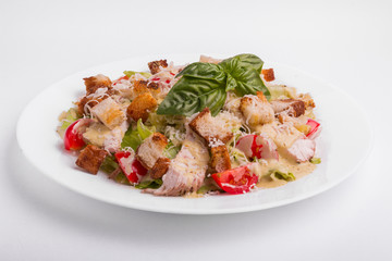 Caesar salad with chicken on a white background
