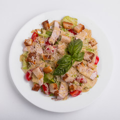 Caesar salad with chicken on a white background