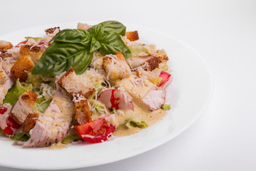 Caesar salad with chicken on a white background