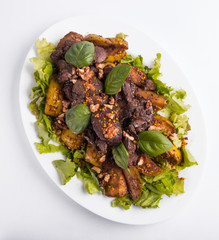 Warm salad with liver and apples on a white background