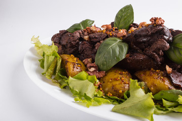 Warm salad with liver and apples on a white background