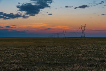 Obraz premium Electrical Transmission Towers at Sunset on the Plains