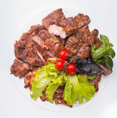 A large plate of meat assorted cooked on a grill