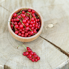 Red currant in a wooden bowl. Top view. The concept is healthy food, vitamins, diet and vegetarianism.