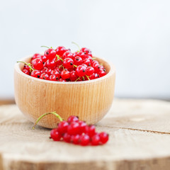 Red currant in a wooden bowl. The concept is healthy food, vitamins, diet and vegetarianism.