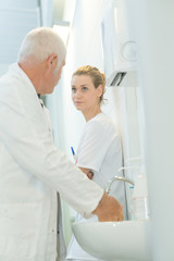 Obraz premium dcotor washing hands and talking to nurse