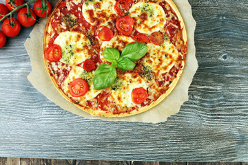 Hot true ITALIAN PIZZA with basil and cheese. TOP VIEW Tasty traditional pepperoni pizza on board on wooden table with decoration
