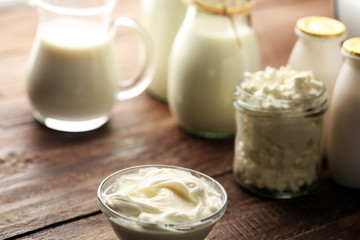 milk products - tasty healthy dairy products on a table on: sour cream in a white bowl, cottage cheese bowl, cream in a a bank and milk jar, glass bottle and in a glass