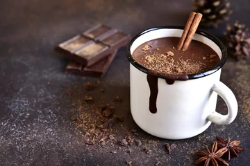 Foto op Plexiglas Chocolade Zelfgemaakte pittige warme chocolademelk met kaneel in emaille mok.