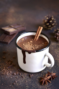 Homemade spicy hot chocolate with cinnamon in enamel mug.