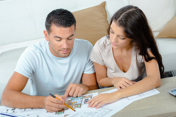young couple planning project of their new home with blueprint