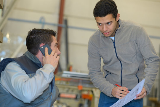warehouse worker talking to boss on smart phone