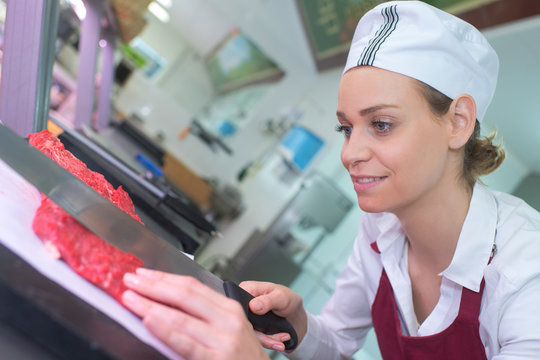portrait of confident female butcher working in kitchen