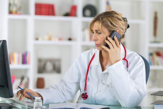 female doctor at her desk talking on phone