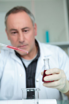 male scientist using chemistry fluid for research in laboratory