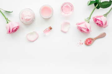 rose organic cosmetics with salt, cream and oil on white table background top view
