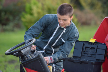 young mechanic fixing something on the tractor