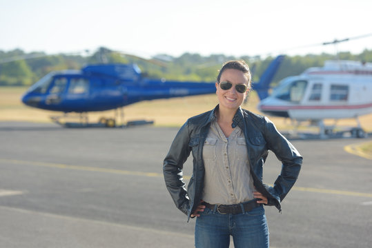 a woman next to an helicopter