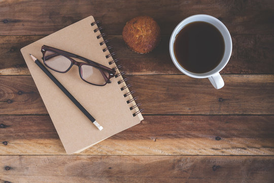 Glasses on notebooks and cups of coffee