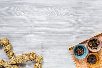 Tea-party with different herbal tea on gray wooden desk background flat lay mock up