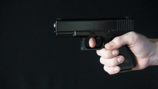 the young man reloads gun black.slow motion