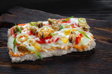 Tasty appetizing japanese rice pizza with mussels served on rustic wooden table.Delicious japanese food