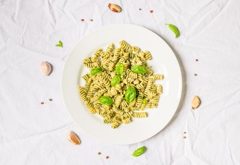 Pasta with basil and cheese pesto against white background