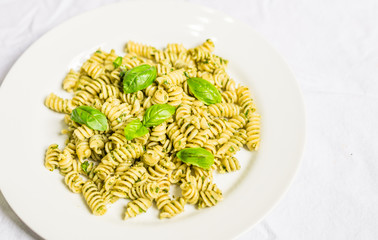 Pasta with basil and cheese pesto against white background
