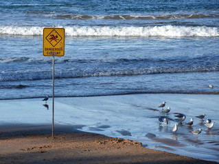 A sign reads Dangerous currents. Swimming is forbidden.