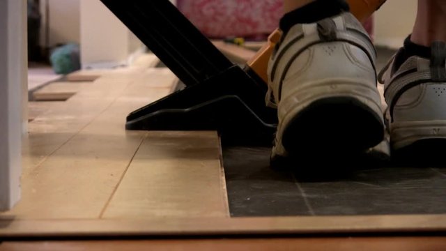 Hardwood flooring being nailed into position with nail gun