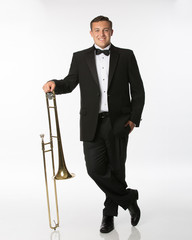 Teenage boy in tuxedo with trombone isolated