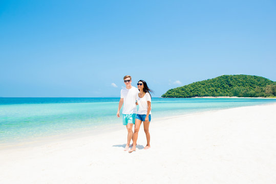 Interracial Couple Walking On Beautiful Beach In Summer