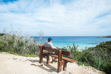 Traveler on a bench on a mountain, in a picturesque place by the sea.
Cyprus. Cape Greco. Ayia Napa
