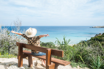 Obraz premium Traveler on a bench on a mountain, in a picturesque place by the sea. Cyprus. Cape Greco. Ayia Napa