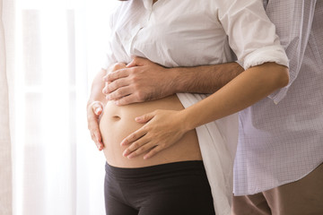 Man holding pregnant  woman belly with carefully, people with family concept.