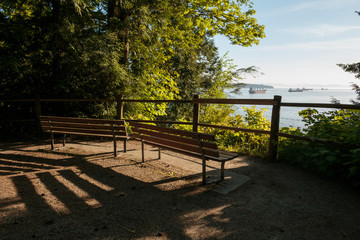 Photo of relaxing benches overlooking the ocean and distant ships