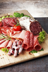 Food tray with delicious salami, pieces of sliced ham, sausage,